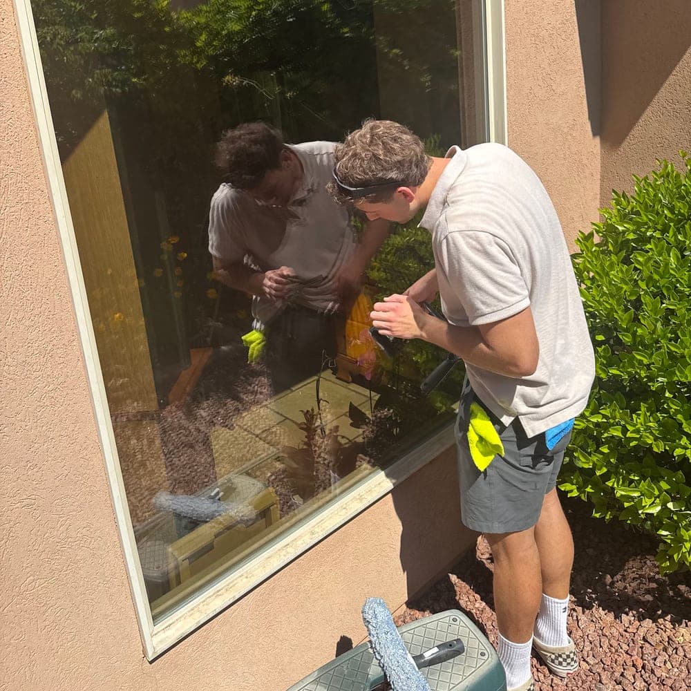 Two technicians working a large window